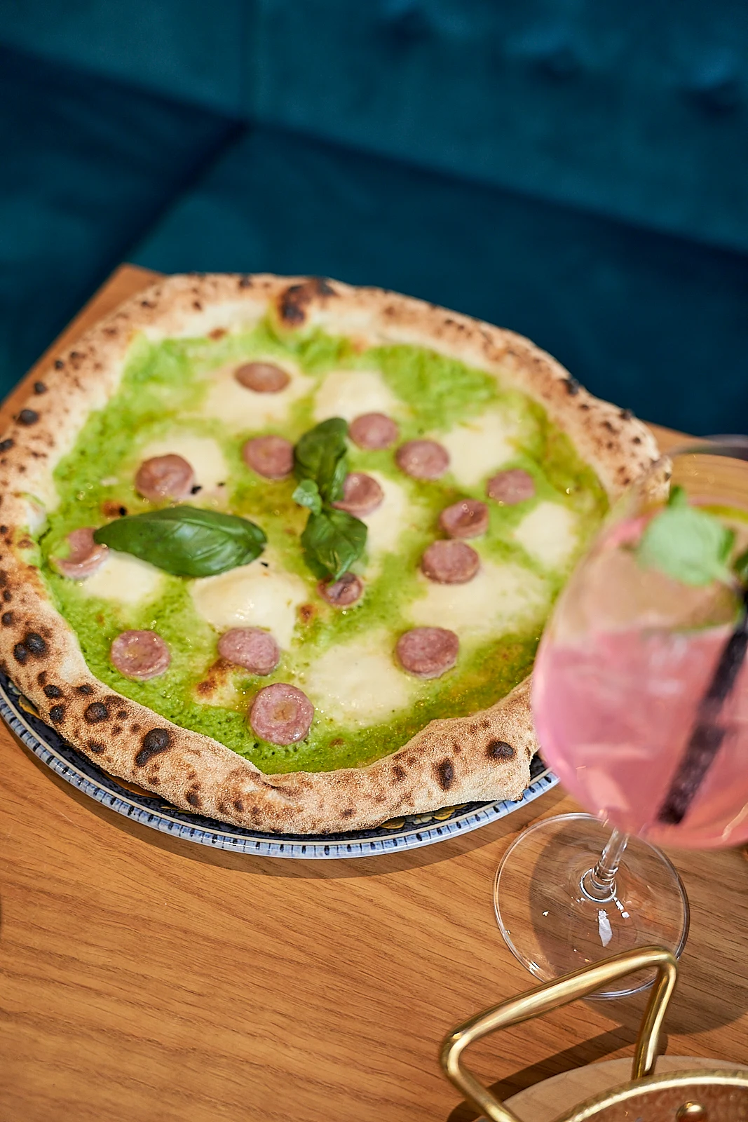Grüne Pizza Napoletana mit Basilikum-Pesto und Salami